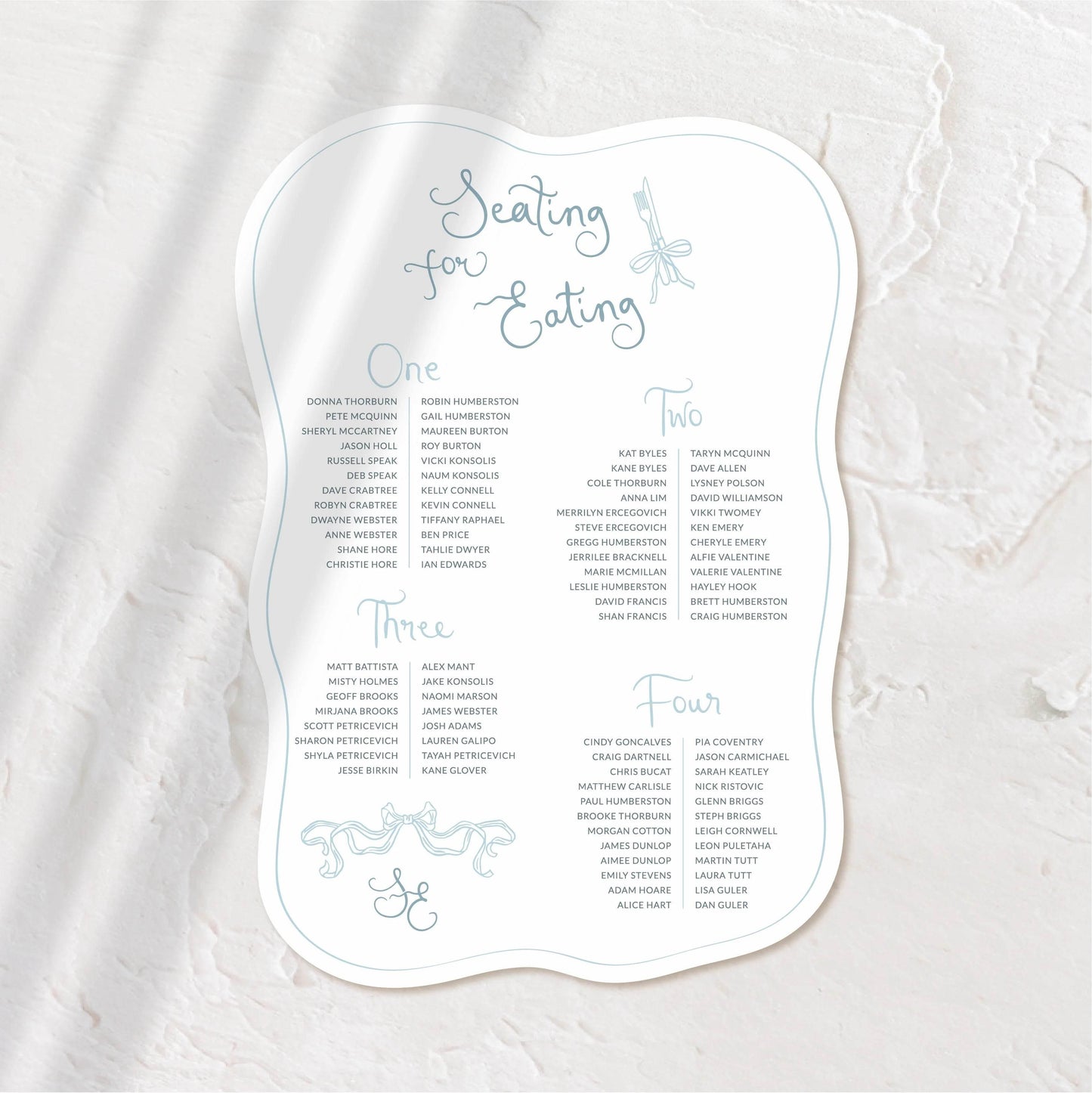 Elegant organic-shaped seating chart with delicate script, perfect for a romantic wedding.