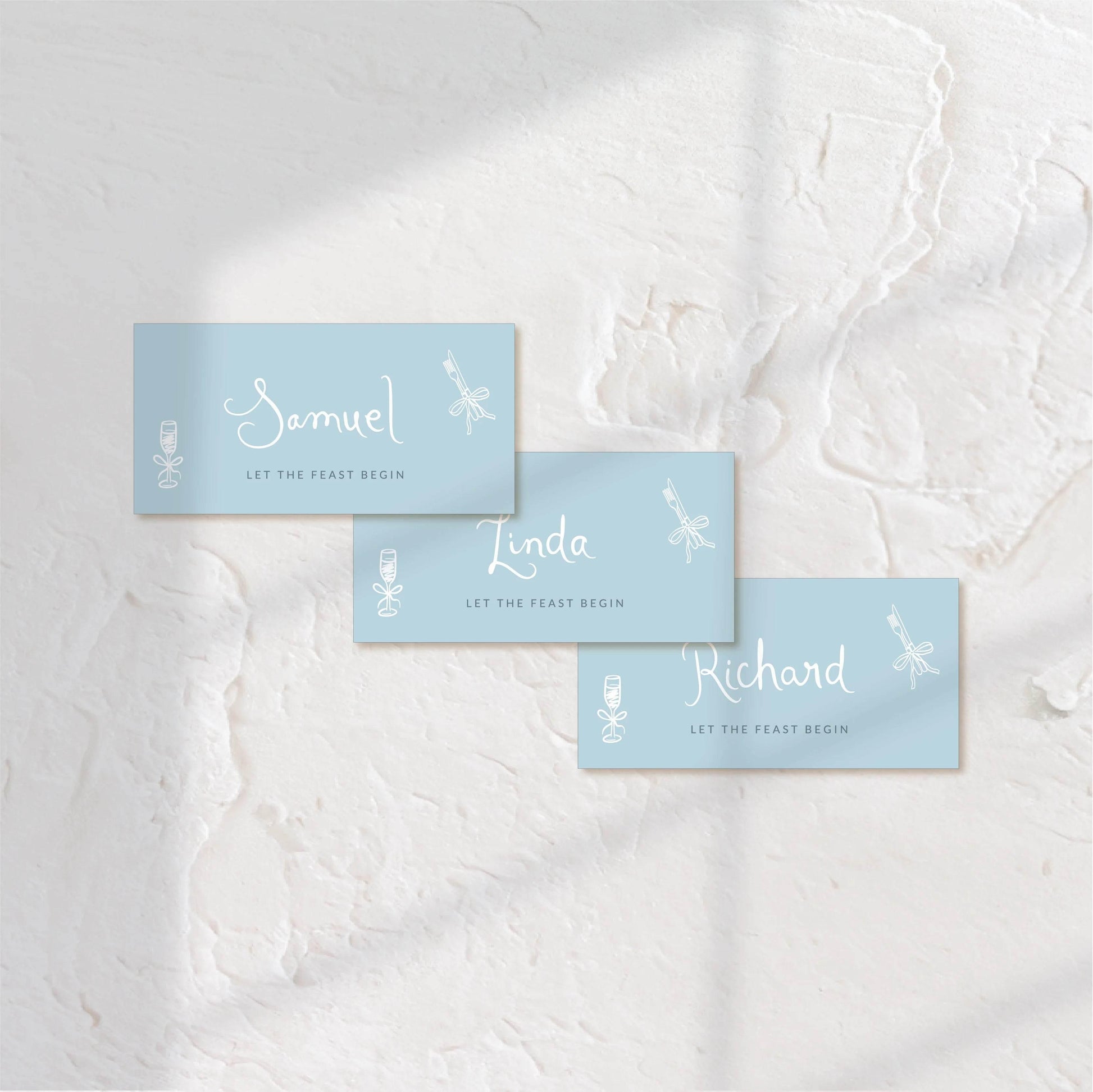Rectangular blue place cards with elegant white type, ideal for modern table settings.