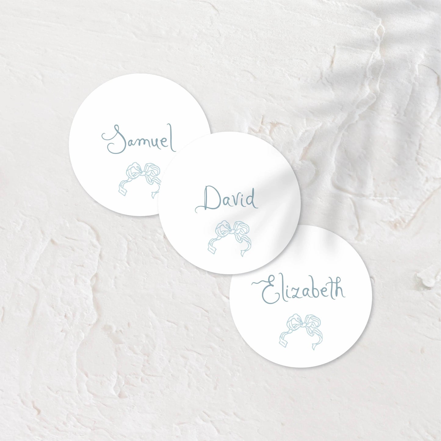 White round place cards with blue tones and simple, elegant text.