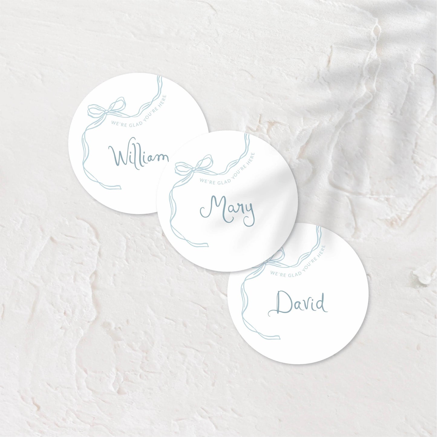 Round place cards with soft pastel tones and playful hand-drawn names.