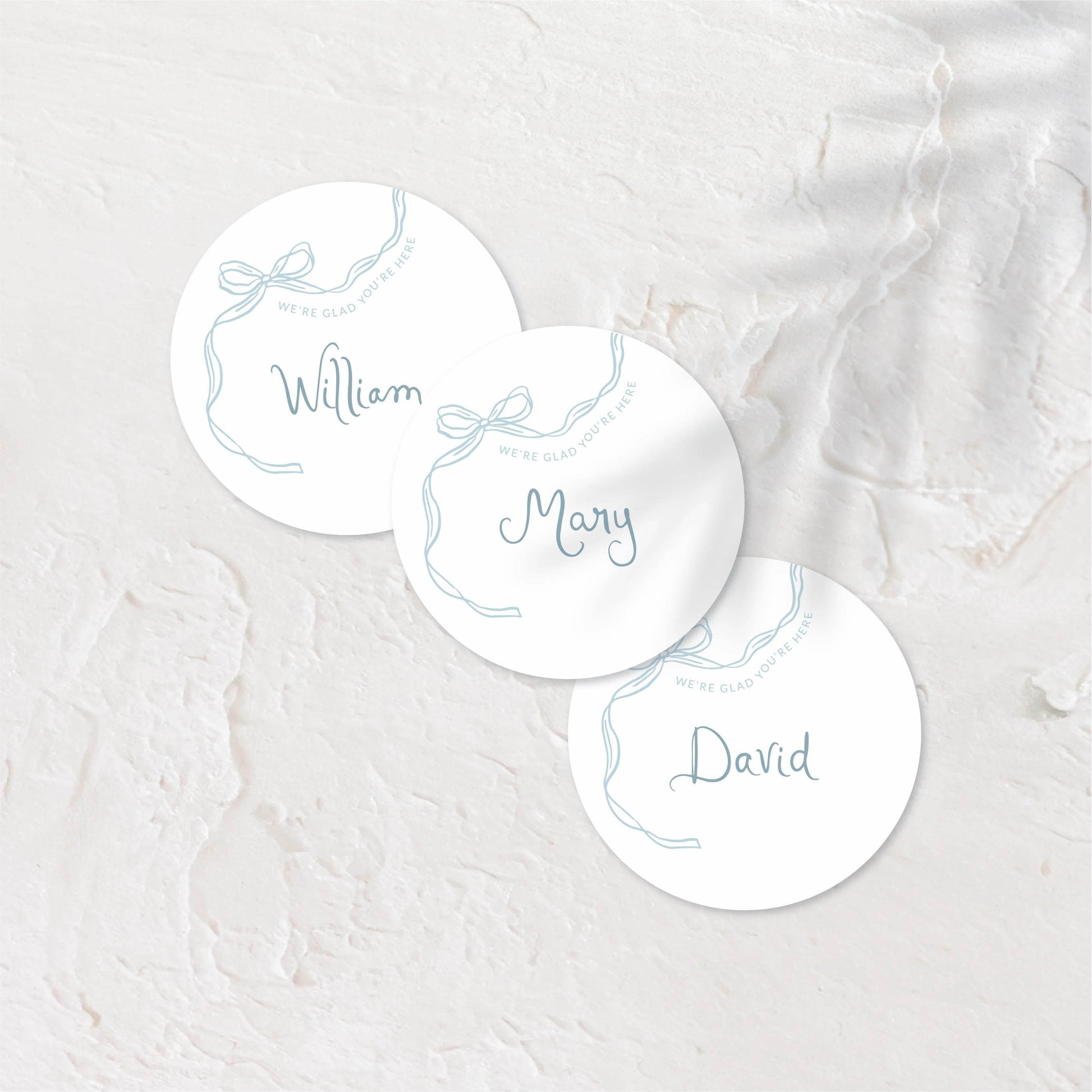 Round place cards with soft pastel tones and playful hand-drawn names.