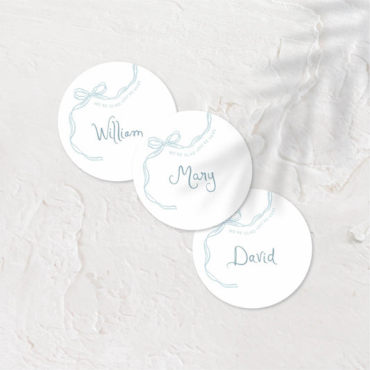 Round place cards with soft pastel tones and playful hand-drawn names.