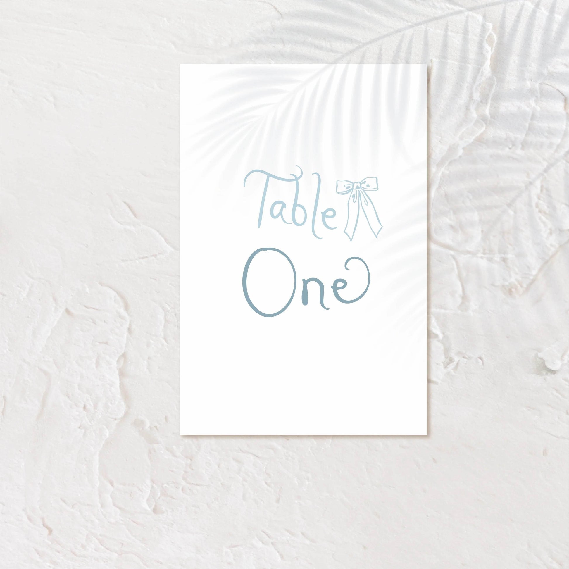 Modern table number card with bold serif text and soft neutral background.