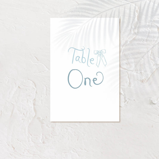 Modern table number card with bold serif text and soft neutral background.