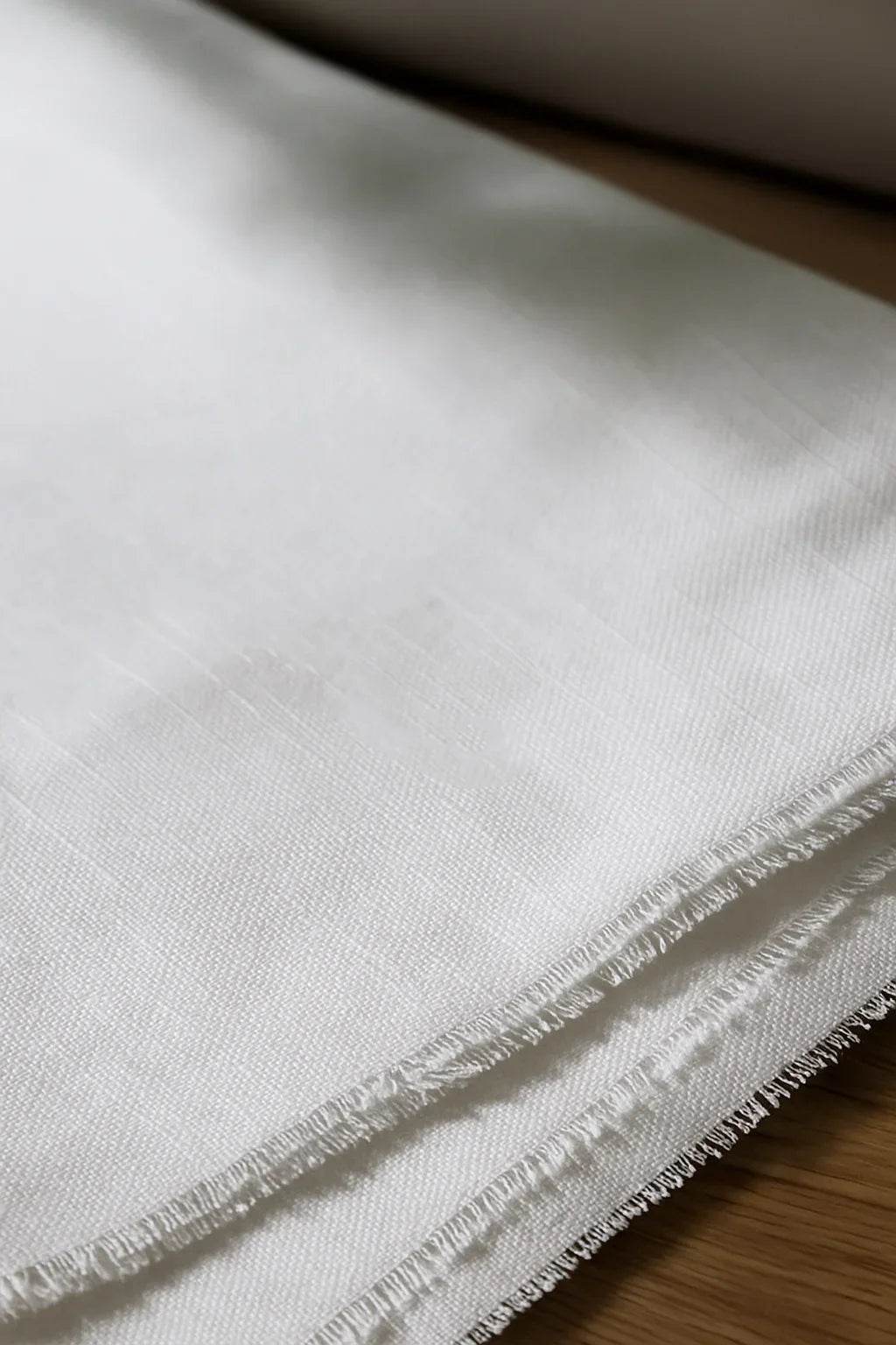 Close-up of a white fabric with black text on a wooden surface