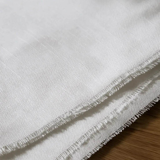 Close-up of a white fabric with black text on a wooden surface